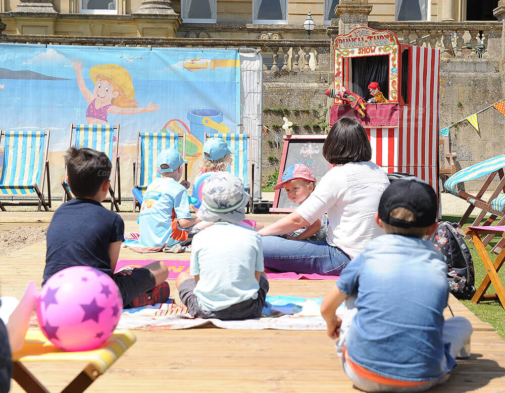 Children watching punch and Judy show at corporate family fun day