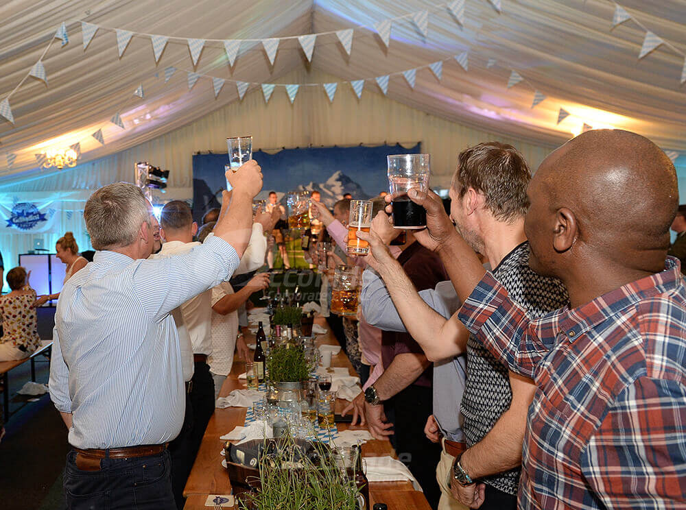 People with raised glasses at German Beer Festival company event