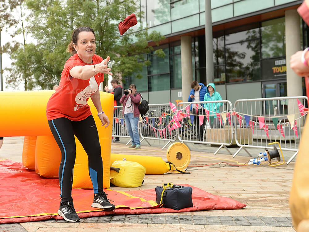 Throwing bean bag to team mate in It's a Knockout corporate event