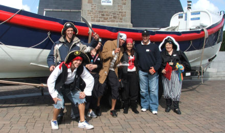 Pirate team posing by lifeboat in Spy Catcher corporate event