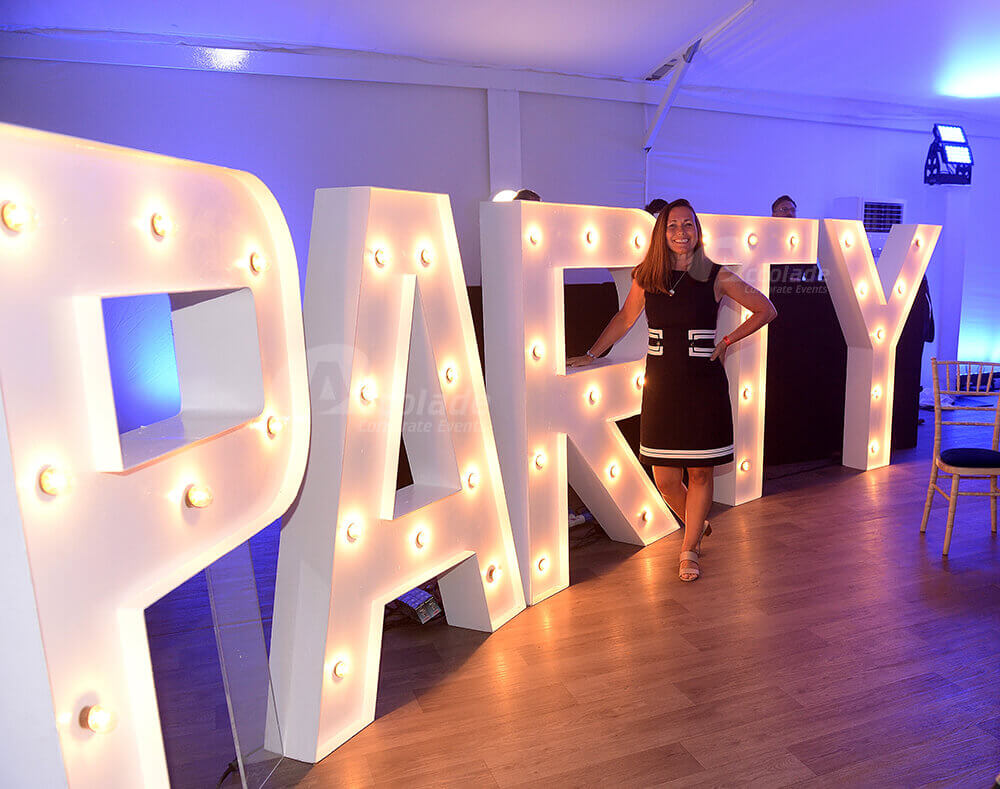 Lady standing by Party sign at company party night