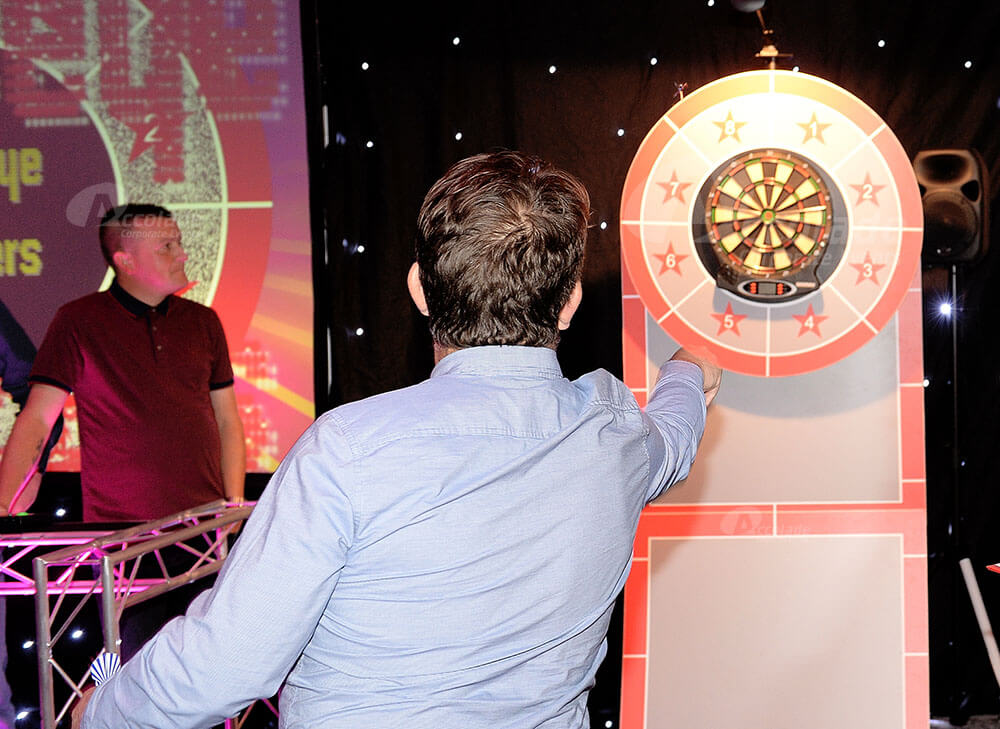 Man throwing darts at company party event