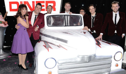 Cadillac and diner sign with vintage 50's rock and roll band