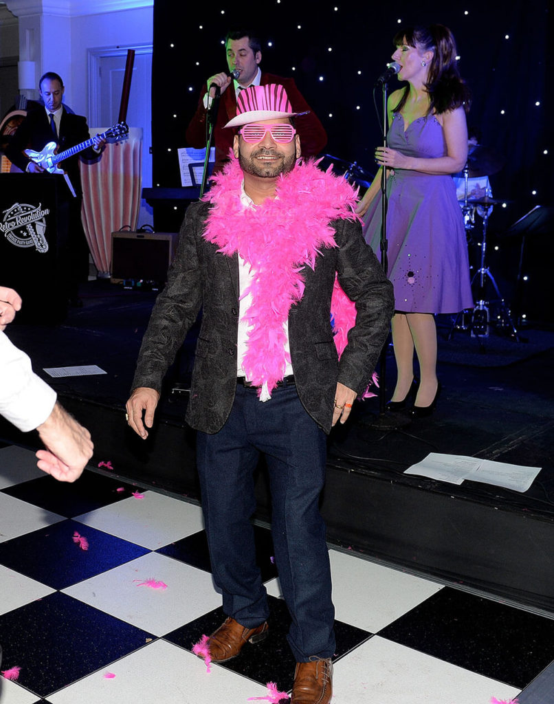 man smiling on chequered dance floor at annual company party