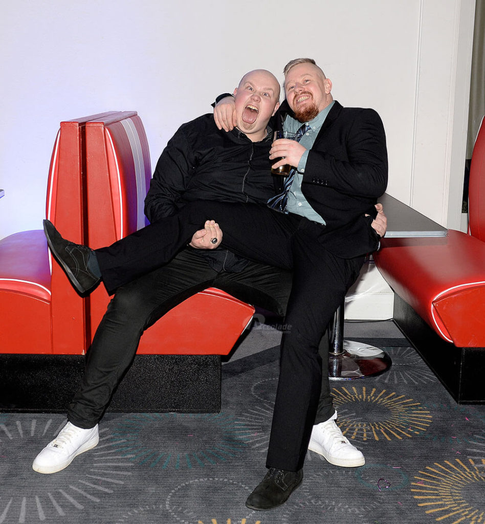 Two men in a diner booth at themed party